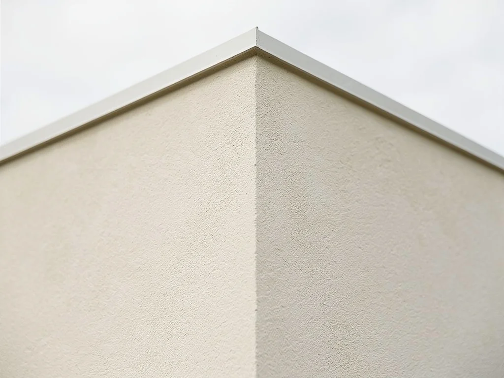 Façade de maison finie à l'enduit minéral clair taloché après isolation par l'extérieur